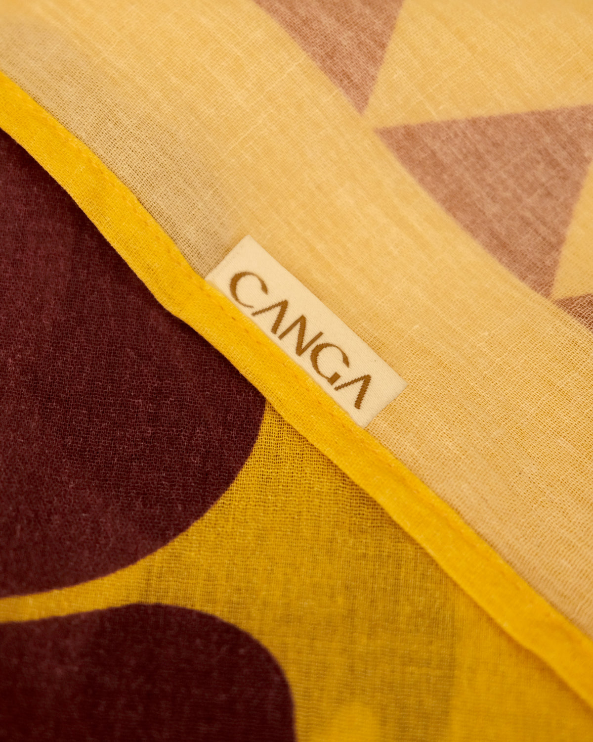 Close-up of Da Mata sarong fabric featuring original tropical print and Canga label